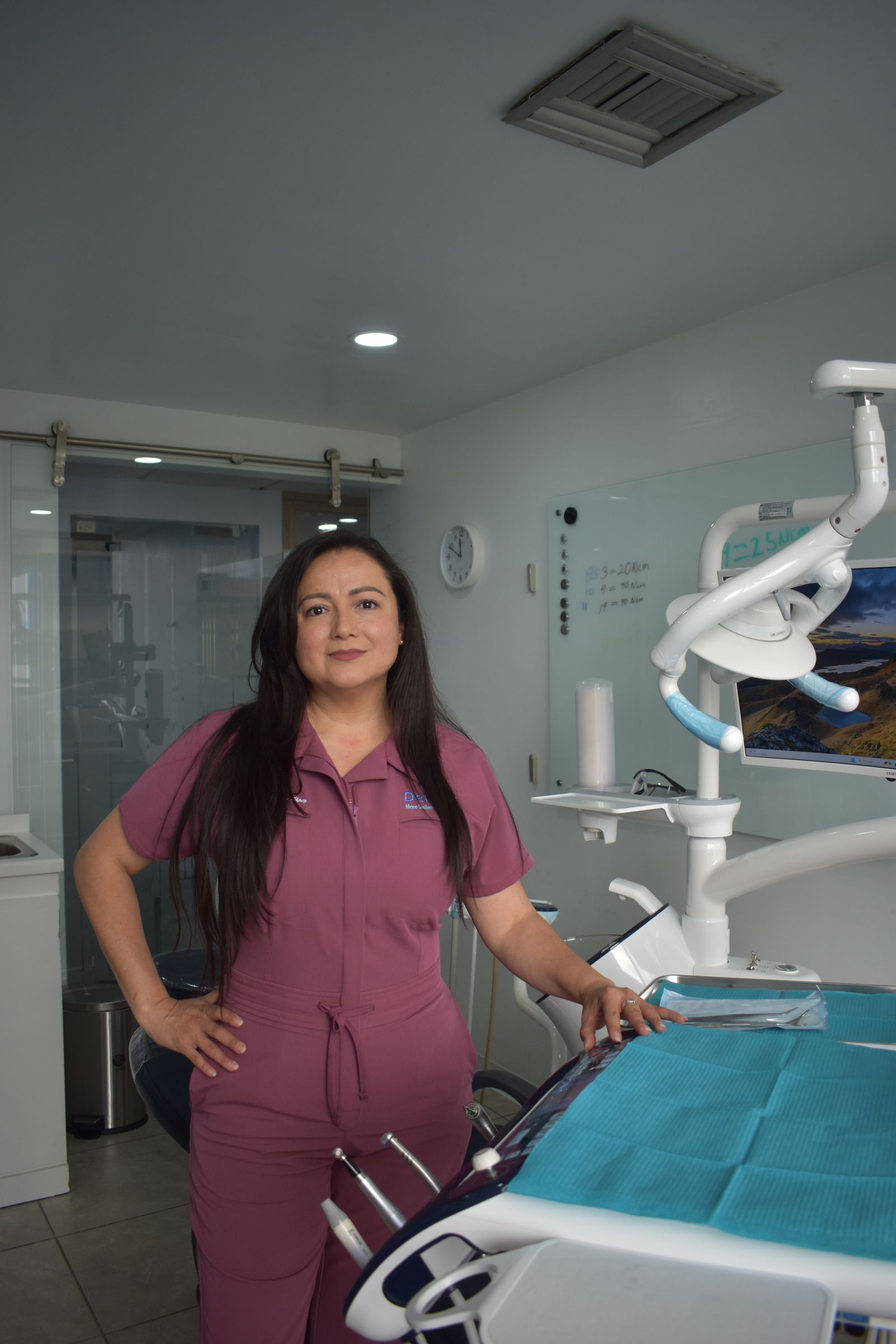 A dental professional standing confidently in a modern clinic